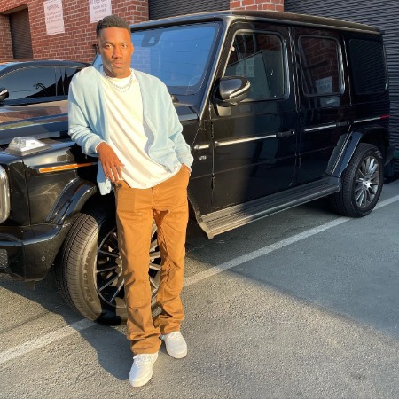 Giveon posing with his luxurious Mercedes-Benz G-Class.